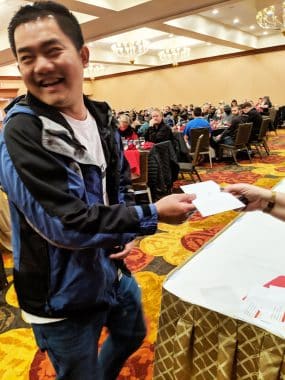 Natoli Engineering Worker Giving Envelope at Christmas in 2018